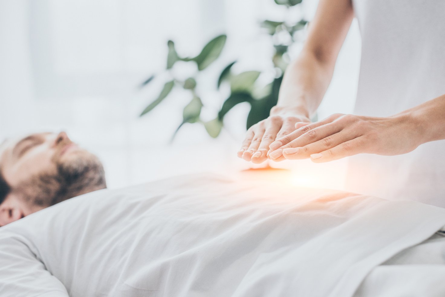 cropped shot of man receiving reiki treatment on stomach